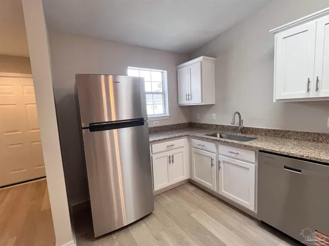 a kitchen with a refrigerator sink and cabinets