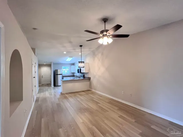 a view of a kitchen with a dishwasher a kitchen island wooden floor and ceiling fan