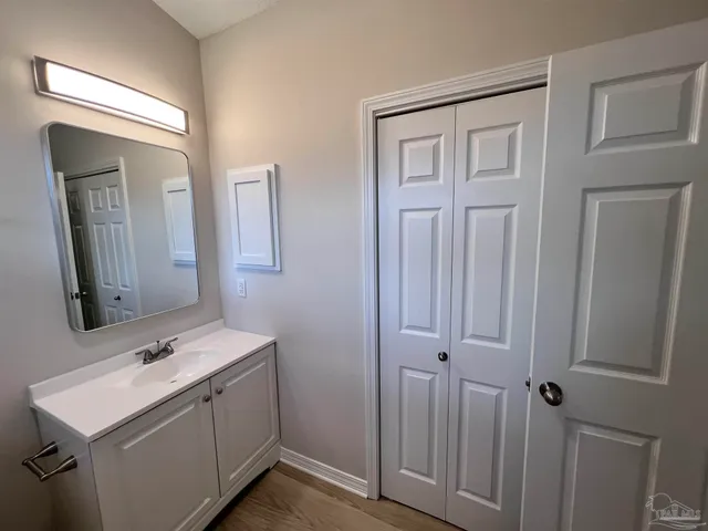 a bathroom with a sink a light fixture a vanity and a mirror