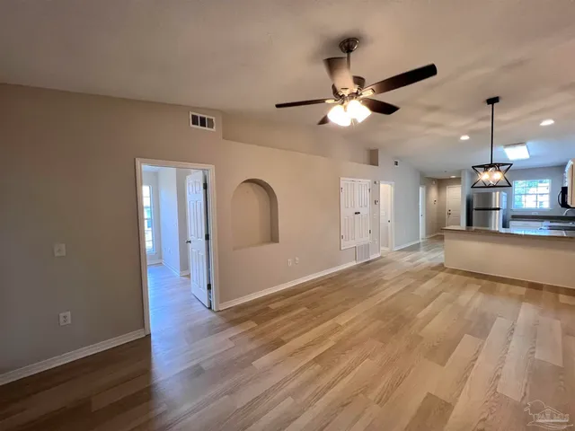 a view of an empty room and kitchen view