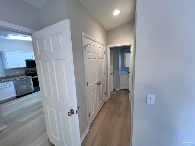 a view of a hallway with wooden floor and staircase
