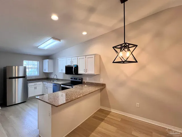 a kitchen with stainless steel appliances granite countertop a sink refrigerator and microwave