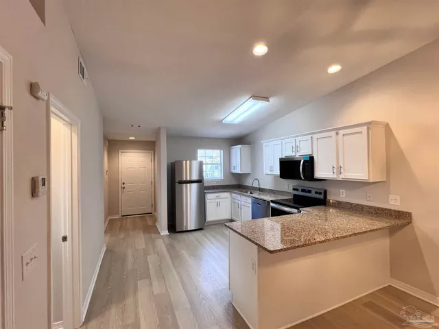 a kitchen with refrigerator and microwave