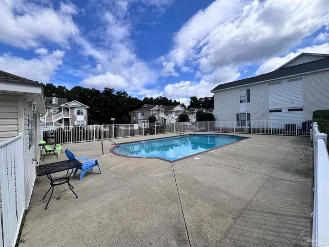 a view of a swimming pool with a lounge chair and a fire pit
