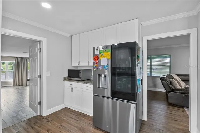 a kitchen with stainless steel appliances a refrigerator and wooden floor