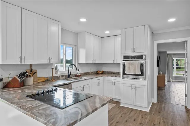 a kitchen with stainless steel appliances granite countertop a sink stove and cabinets