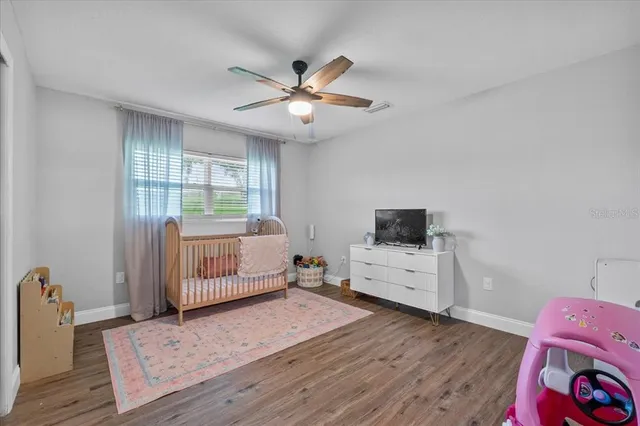 a view of a room with wooden floor and ceiling fan