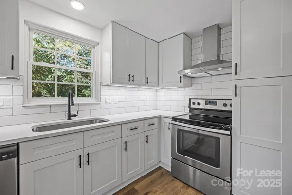 a kitchen with cabinets stainless steel appliances a sink and window