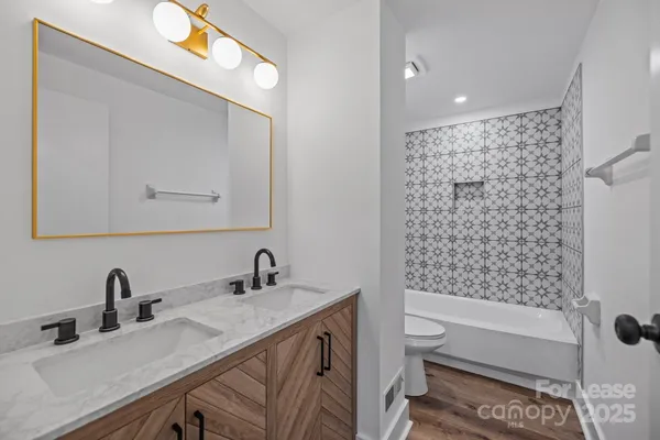 a bathroom with a double vanity sink toilet and shower