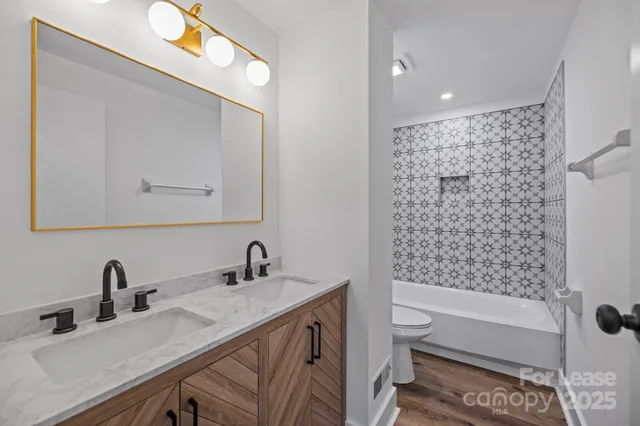 a bathroom with a double vanity sink toilet and shower