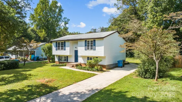 a front view of a house with a yard and trees