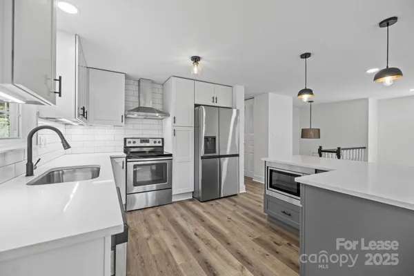 a kitchen with kitchen island stainless steel appliances a sink stove and refrigerator