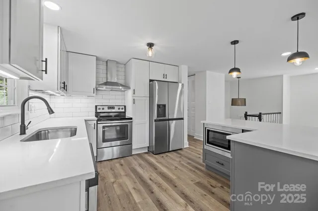 a kitchen with kitchen island stainless steel appliances a sink stove and refrigerator