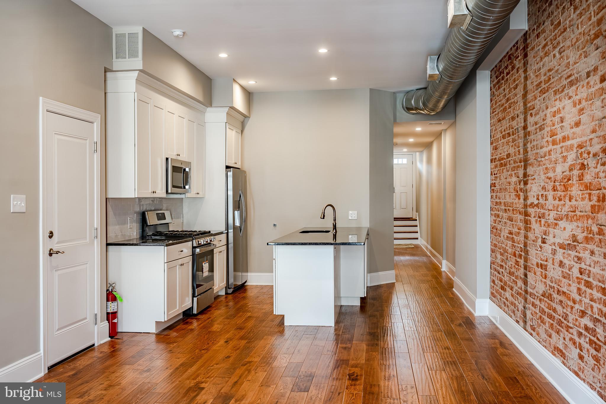 226 Bridge Street, Unit 2 Phoenixville, PA 19460 - Photo 11 of 25 a kitchen with stainless steel appliances granite countertop a refrigerator a stove and a wooden floors