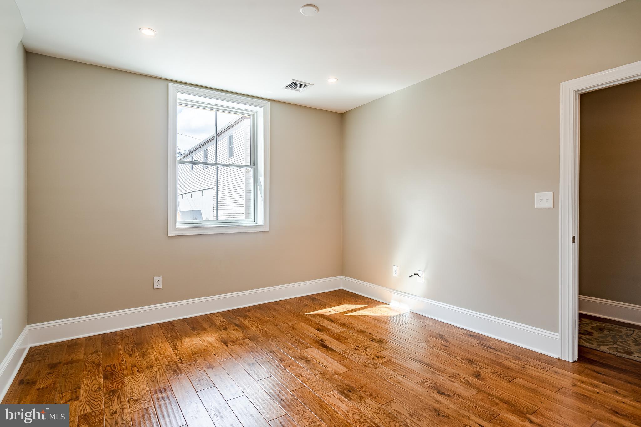 226 Bridge Street, Unit 2 Phoenixville, PA 19460 - Photo 13 of 25 an empty room with wooden floor and windows
