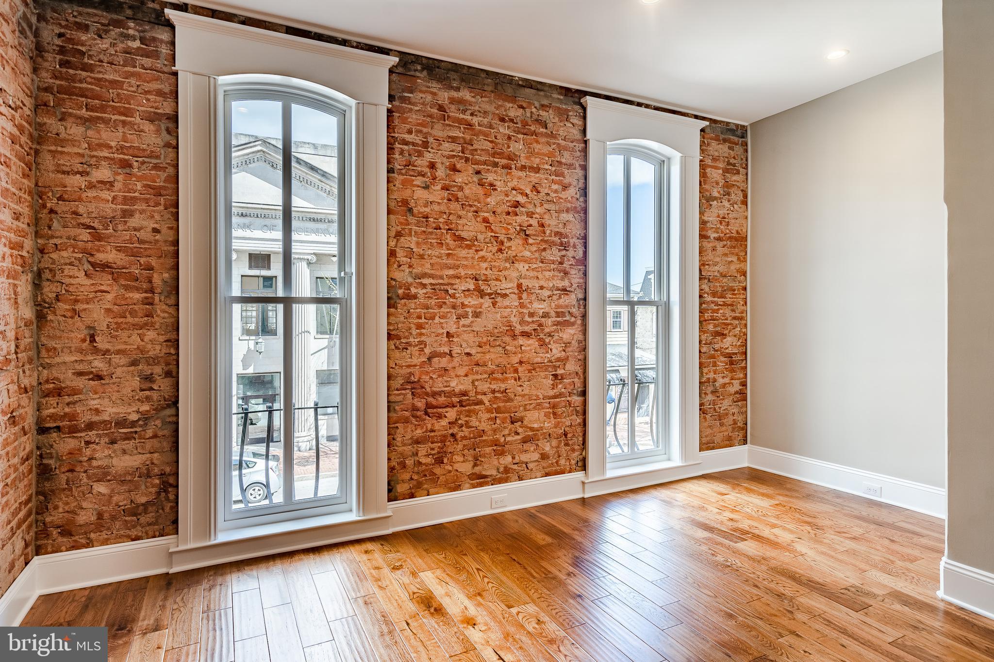 226 Bridge Street, Unit 2 Phoenixville, PA 19460 - Photo 3 of 25 an empty room with wooden floor and windows