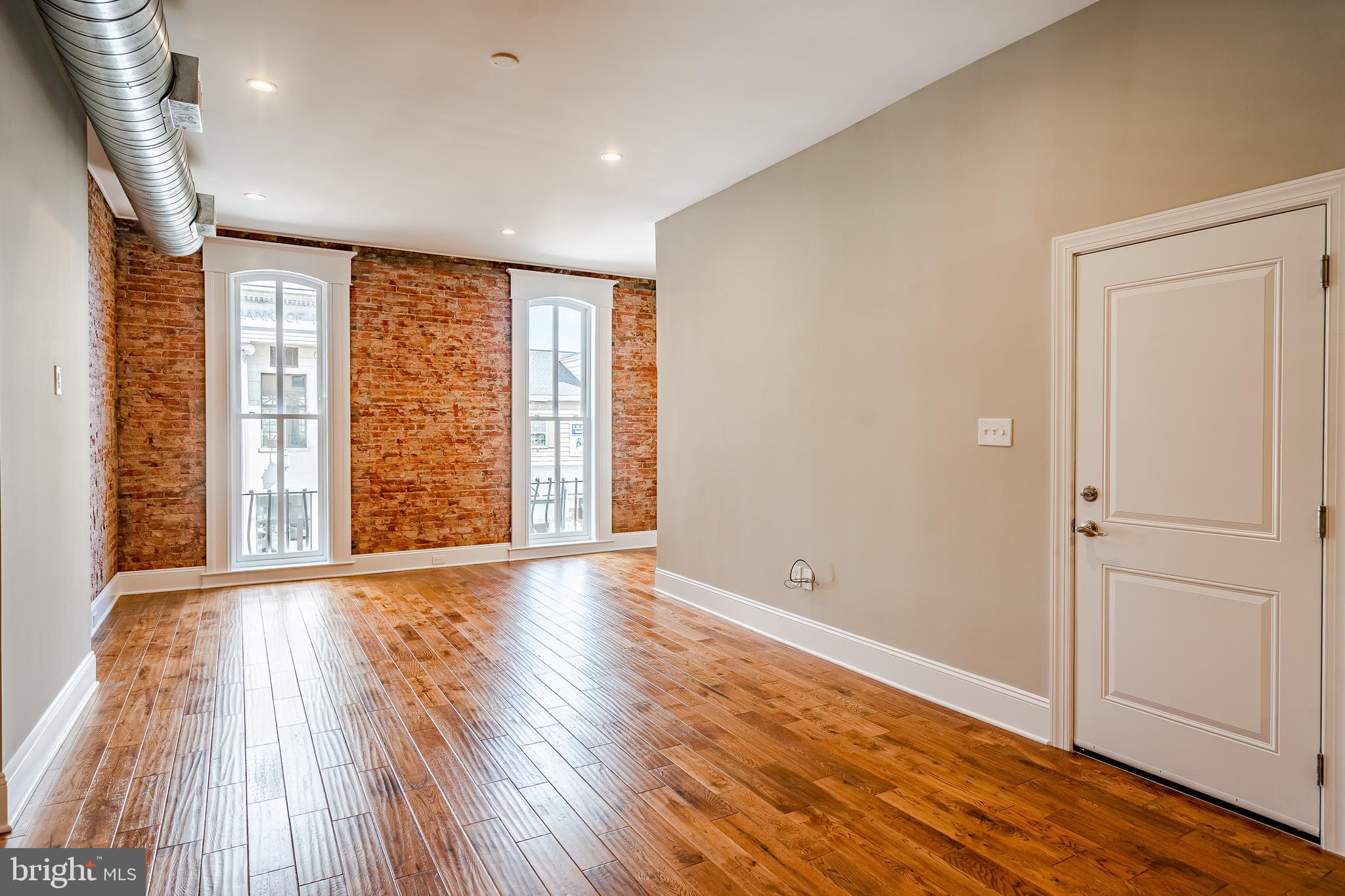 226 Bridge Street, Unit 2 Phoenixville, PA 19460 - Photo 4 of 25 a view of an empty room with wooden floor and a window