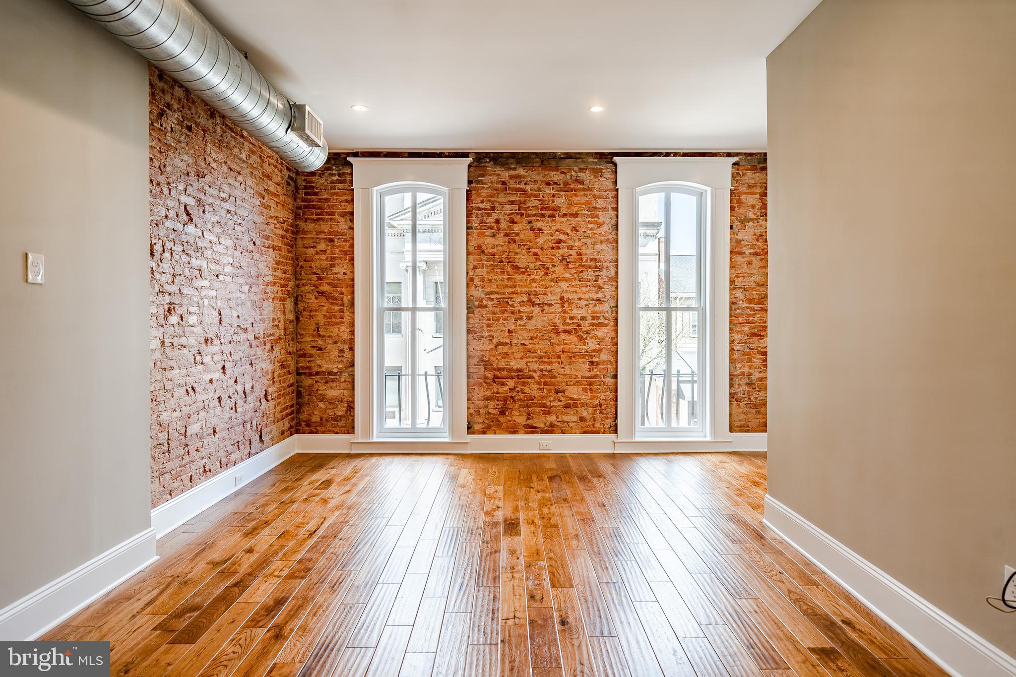 226 Bridge Street, Unit 2 Phoenixville, PA 19460 - Photo 5 of 25 a view of an empty room with wooden floor and a window