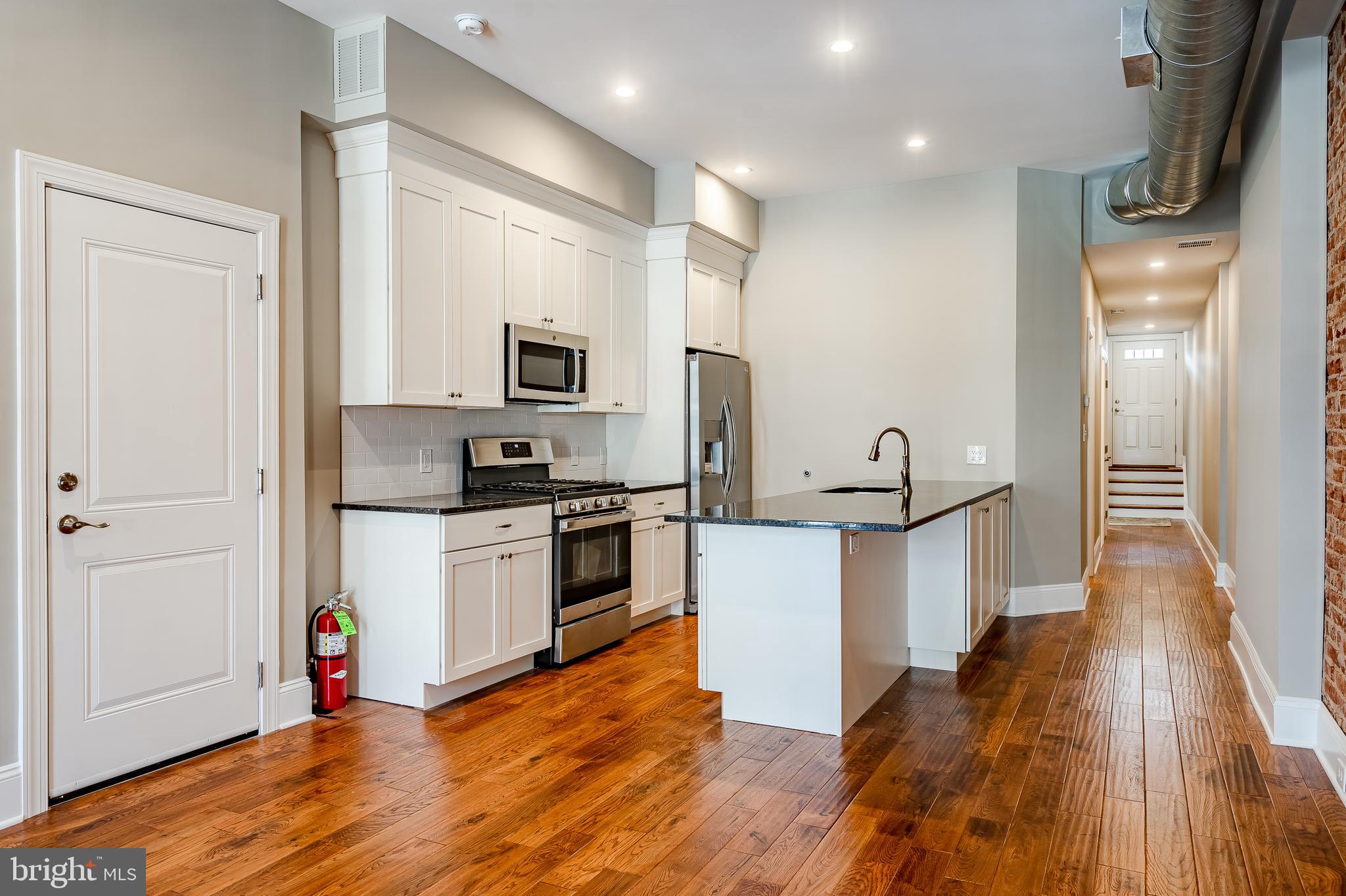 226 Bridge Street, Unit 2 Phoenixville, PA 19460 - Photo 6 of 25 a kitchen with white cabinets and stainless steel appliances