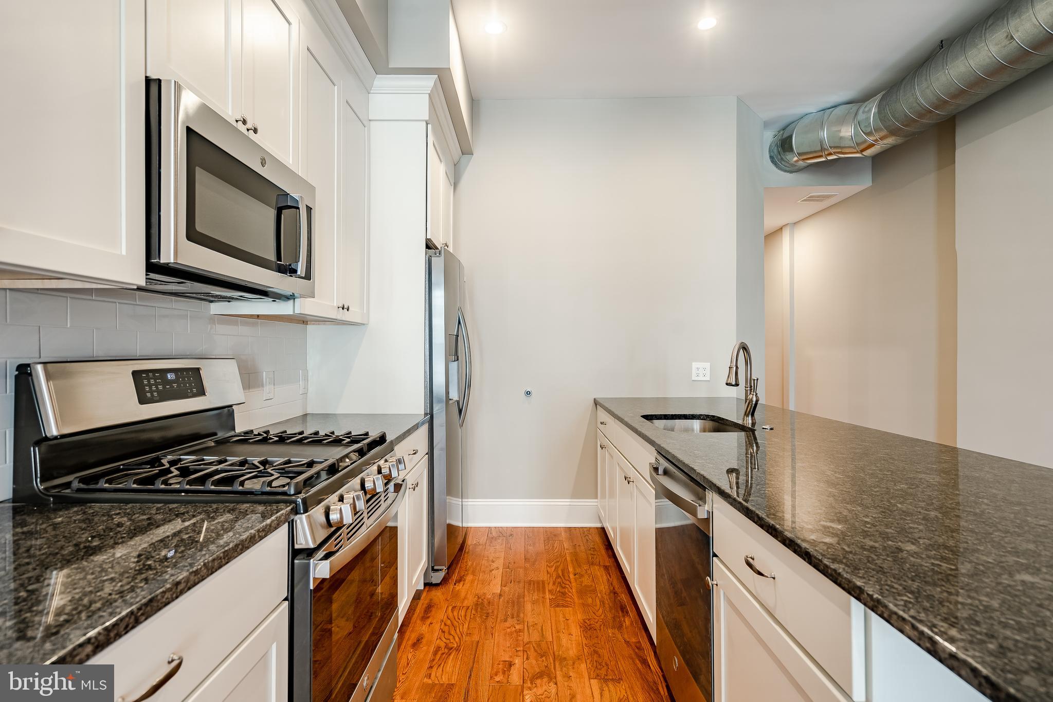 226 Bridge Street, Unit 2 Phoenixville, PA 19460 - Photo 10 of 25 a kitchen with stainless steel appliances granite countertop a stove and a sink