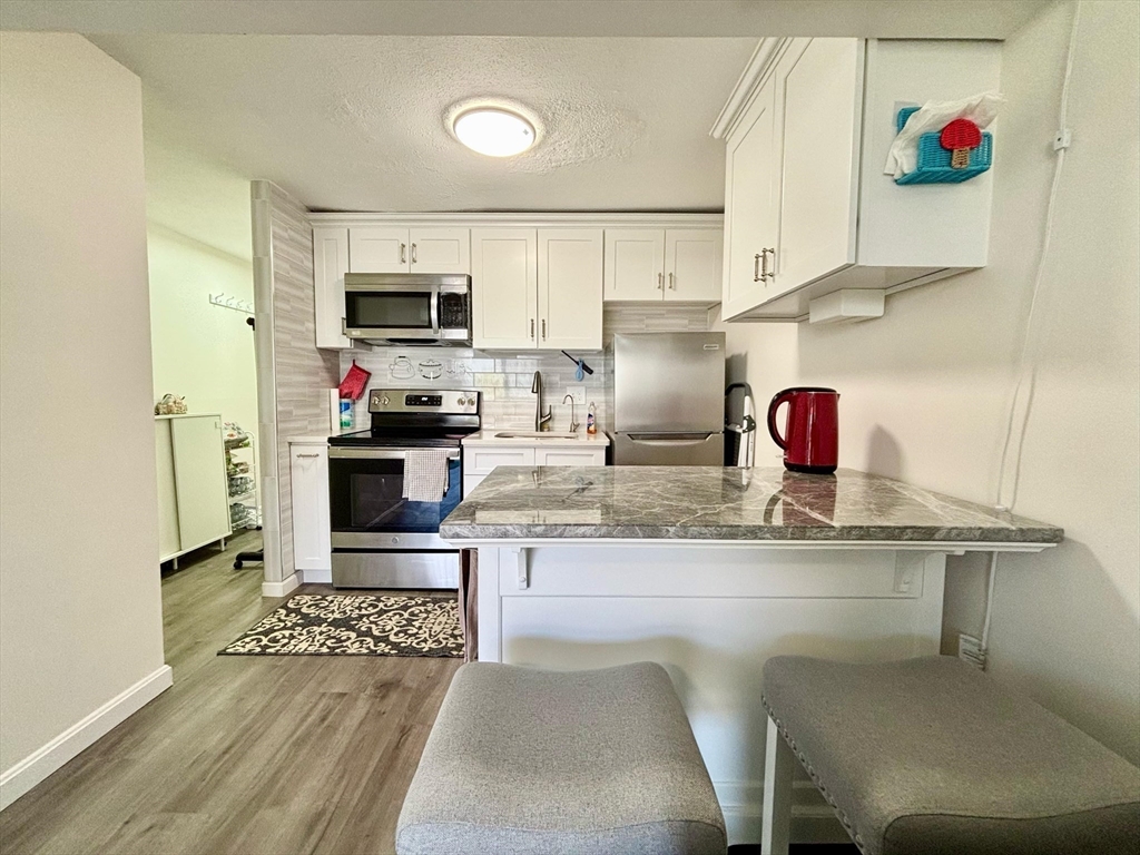 175 Ward Street, Unit 35 Revere, MA 02151 - Photo 4 of 19 a kitchen with granite countertop a sink cabinets and stainless steel appliances