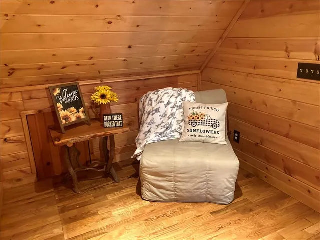 a bed sitting in a bedroom next to a window with wooden floor