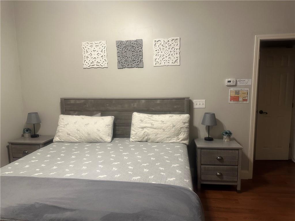 105 Ranch Mountain Court Dahlonega, GA 30533 - Photo 36 of 70 a bed sitting in a bedroom next to a window with wooden floor