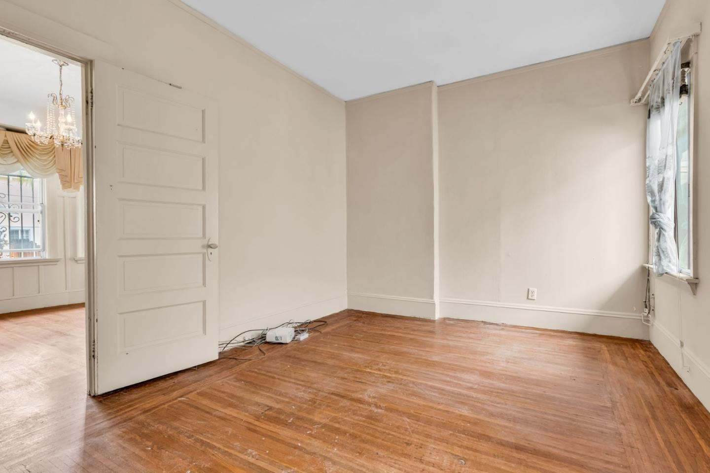 852 58th Street Oakland, CA 94608 - Photo 17 of 64 an empty room with wooden floor and windows
