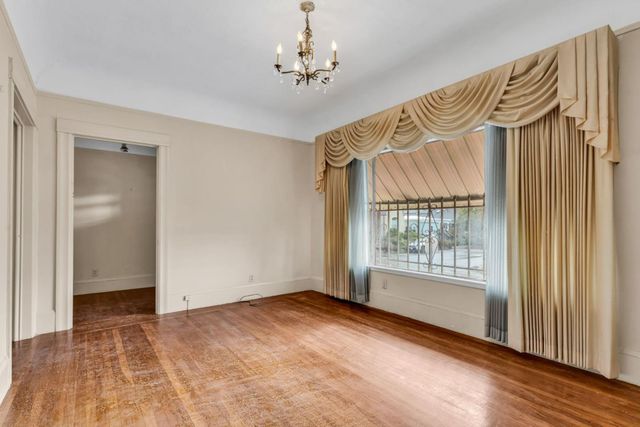 a view of a hallway with wooden floor and a chandelier