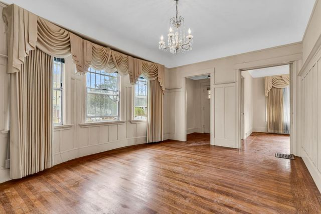 an empty room with wooden floor and cabinet