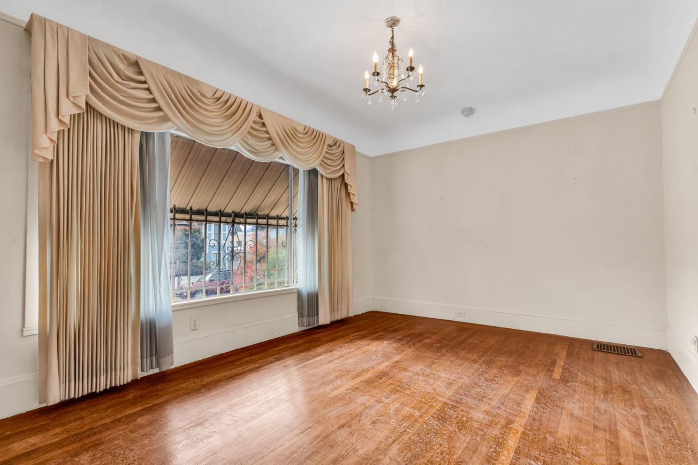852 58th Street Oakland, CA 94608 - Photo 31 of 64 a view of an empty room with a window and wooden floor