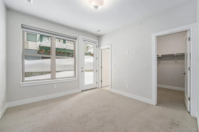 an empty room with windows and closet