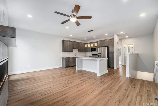 a view of kitchen with granite countertop cabinets and refrigerator