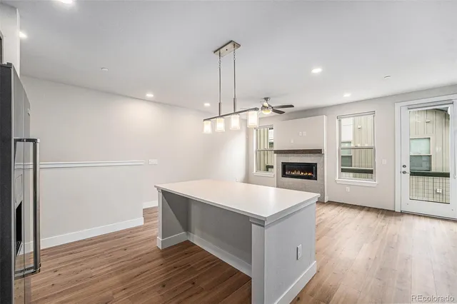 a large kitchen with hardwood floor a sink a counter and stainless steel appliances