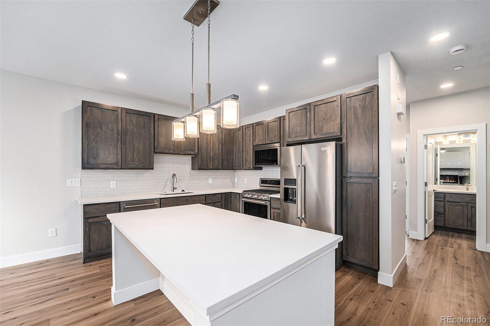 15 Explorers Avenue Fraser, CO 80442 - Photo 9 of 25 a kitchen with a refrigerator a sink and wooden floor