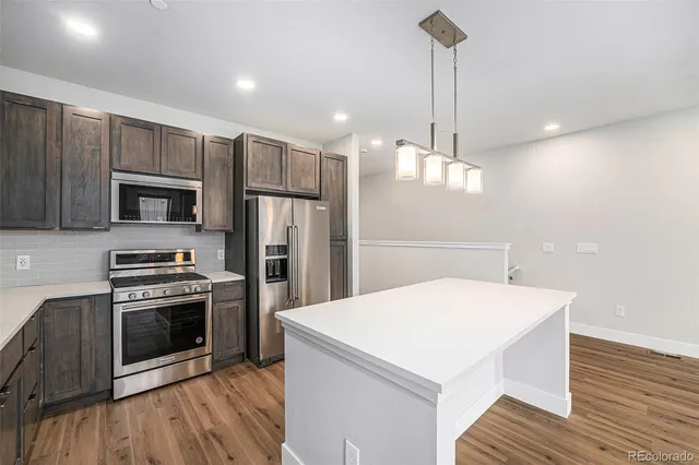 a kitchen with a sink a microwave a stove and refrigerator