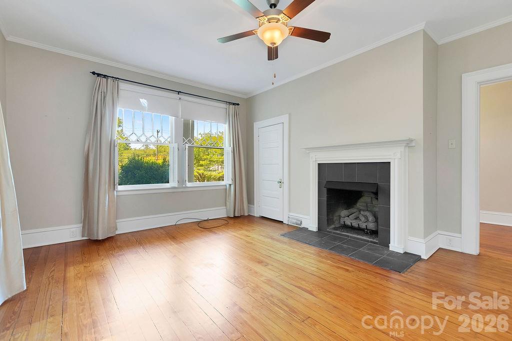 208 West Probart Street Brevard, NC 28712 - Photo 20 of 48 a view of an empty room with wooden floor fireplace and a window