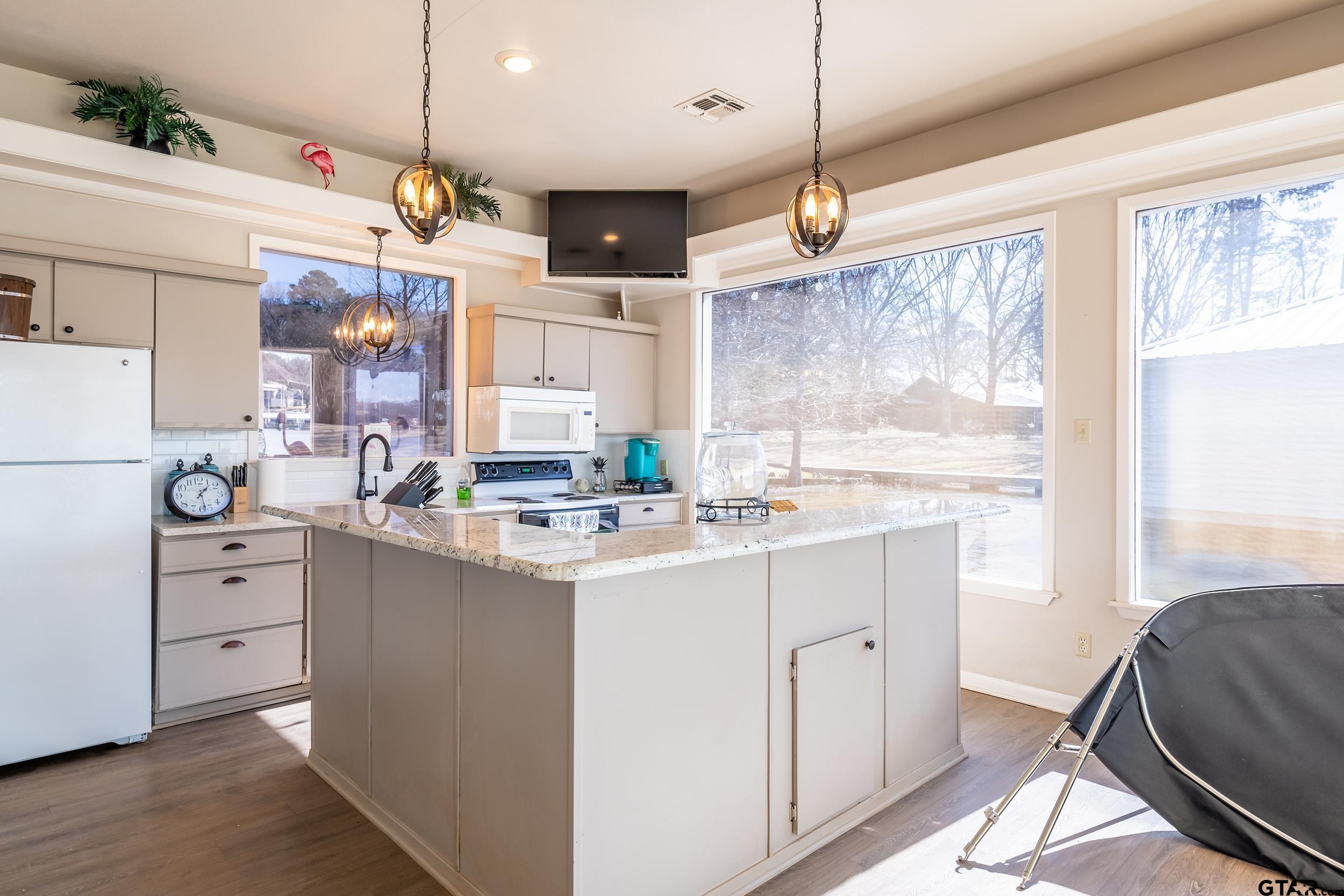 13793 Peninsula Road Whitehouse, TX 75791 - Photo 47 of 48 a kitchen with kitchen island granite countertop a sink appliances cabinets and a large window