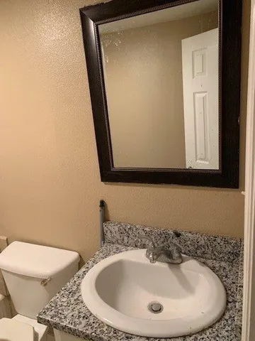 a bathroom with a toilet sink and mirror