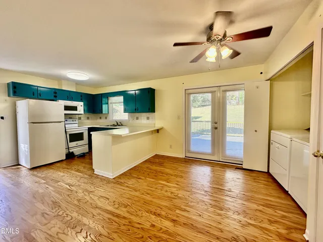 a view of a kitchen with a sink oven cabinets and wooden floor