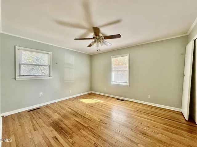 a view of a room with wooden floor and a ceiling fan