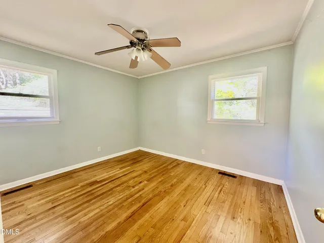 a view of empty room with wooden floor