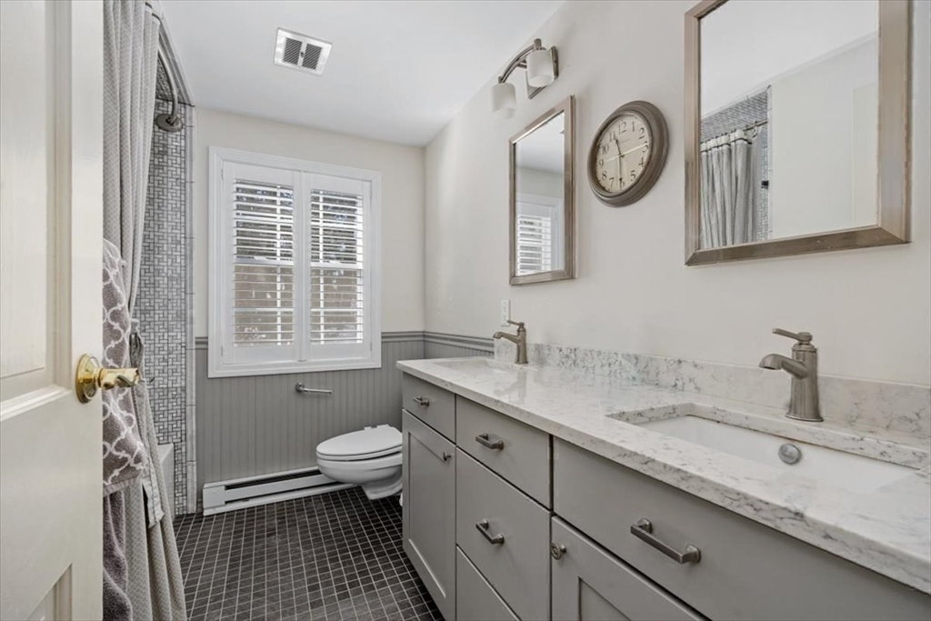 5 Old County Road Hingham, MA 02043 - Photo 32 of 42 a bathroom with a granite countertop sink a toilet and a large mirror