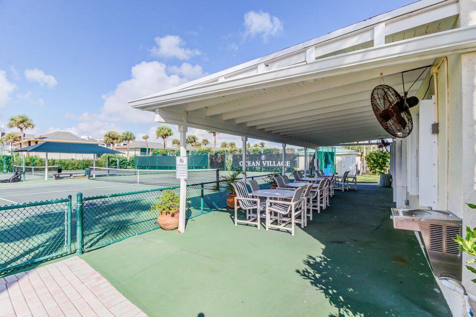 1002 Windward Drive Fort Pierce, FL 34949 - Photo 52 of 122 a view of a patio with table and chairs potted plants with floor to ceiling window and outdoor kitchen