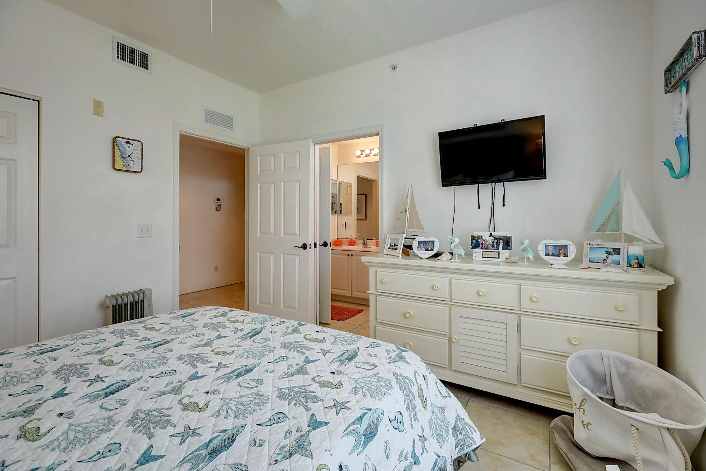 1002 Windward Drive Fort Pierce, FL 34949 - Photo 77 of 122 a spacious bedroom with a bed and a flat screen tv