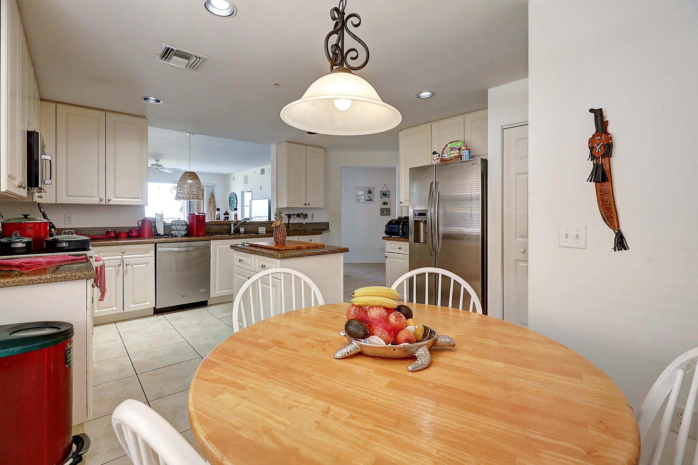 1002 Windward Drive Fort Pierce, FL 34949 - Photo 87 of 122 a kitchen with stainless steel appliances granite countertop a stove a sink dishwasher and white cabinets with wooden floor