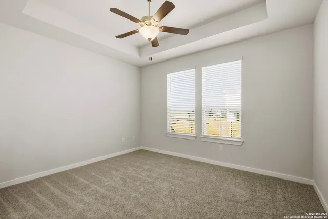 an empty room with a window and a fan