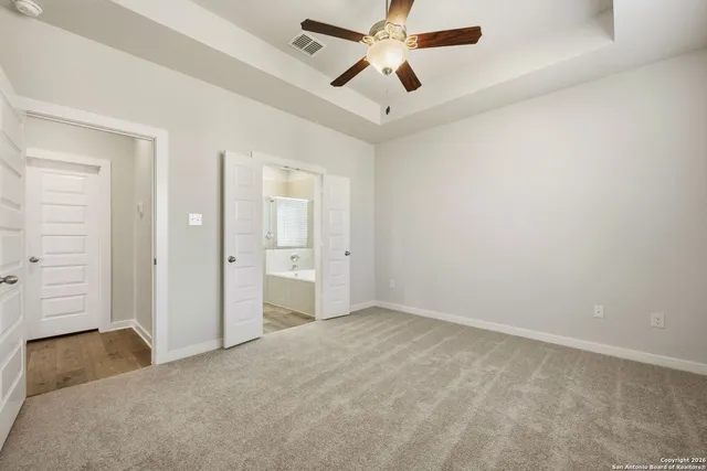 an empty room with closet and a chandelier fan