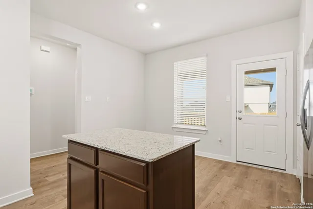 an empty room with wooden floor and window