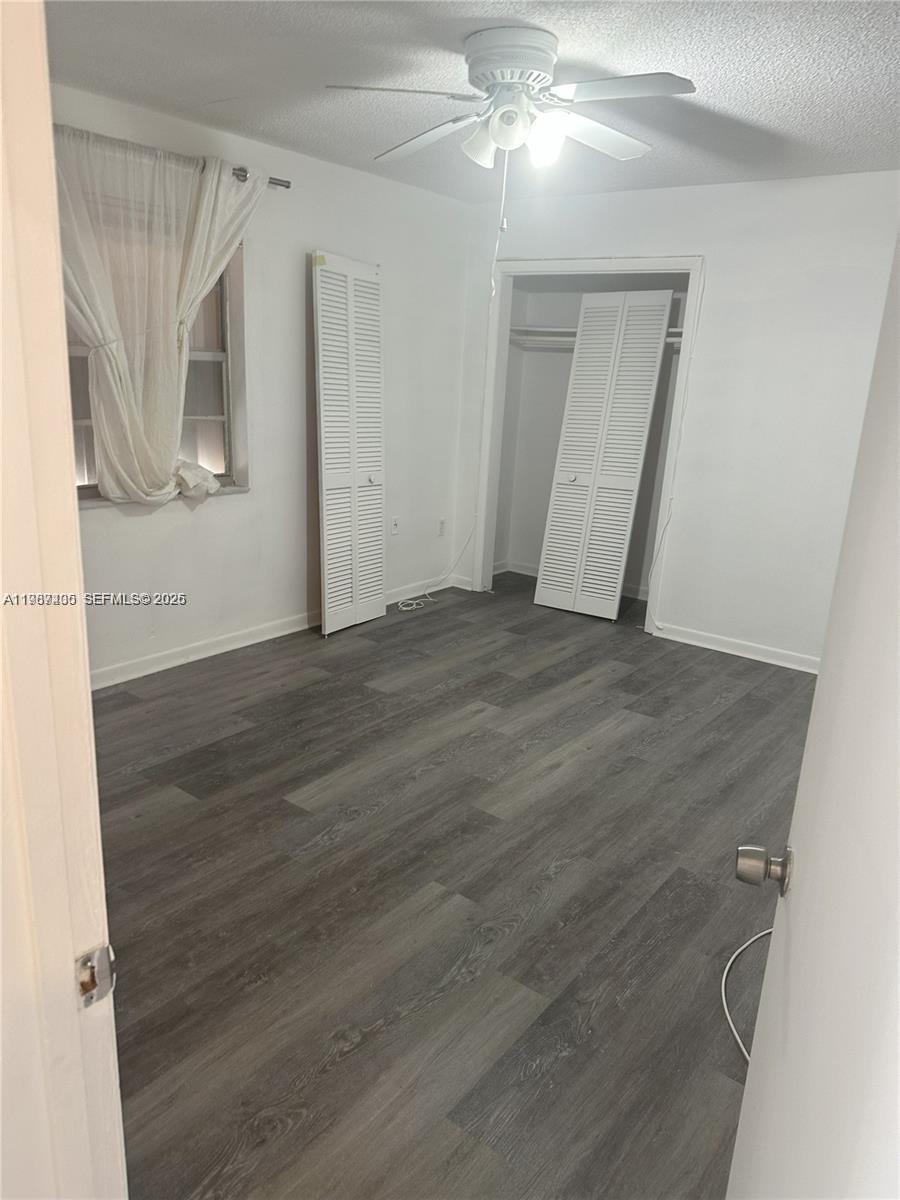 3268 Southwest 25th Street, Unit 3268 Miami, FL 33133 - Photo 11 of 17 a view of an empty room with wooden floor and a ceiling fan